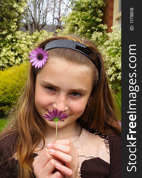 Beautiful young girl smelling flower