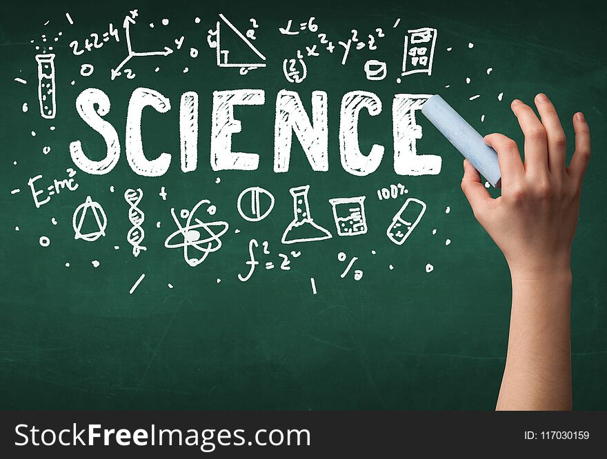 A teacher writing science, drawing chemistry elements on clean green chalkboard by hand. A teacher writing science, drawing chemistry elements on clean green chalkboard by hand
