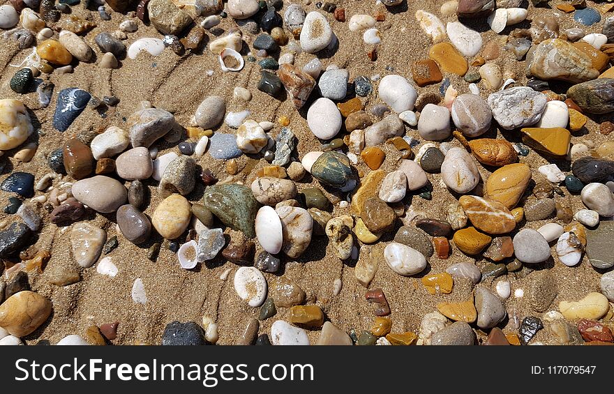 Wet sea pebbles and seashells on the wet beach sand. Natural sea stones in the sea surf line. Beach smooth pebbles closeup. Tourism and travel theme. Beach vacation background. Wet sea pebbles and seashells on the wet beach sand. Natural sea stones in the sea surf line. Beach smooth pebbles closeup. Tourism and travel theme. Beach vacation background.