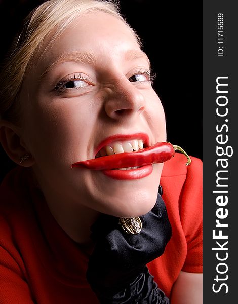 Hot blond girl with red pepper in her teeth. Hot blond girl with red pepper in her teeth