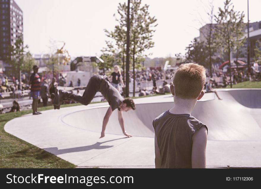 Man in Black Tank Top Looking at Man in Black T-shirt Doing Hand Stand Routine