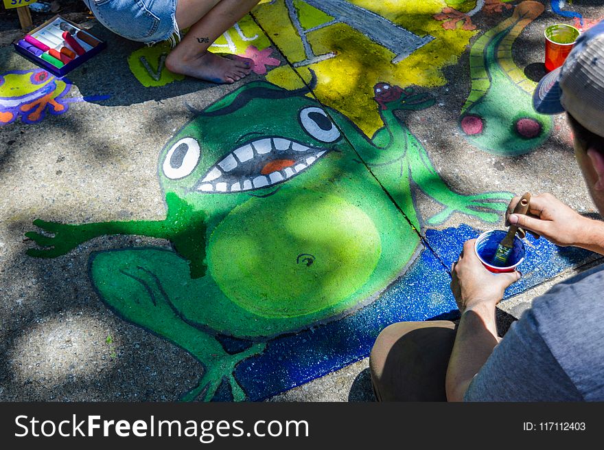 Man Painting Green Frog On Ground