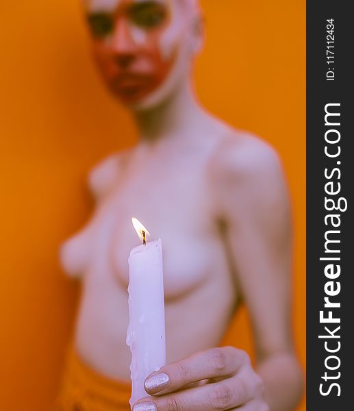 Shallow Focus Photography of Topless Woman Holding White Candle