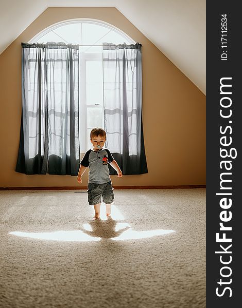 Boy Wearing Gray T-shirt and Gray Cargo Shorts Inside White Painted Wall Room
