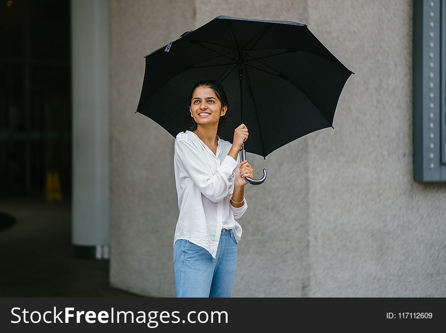 Woman in White Button-up Long-sleeved Shirt Holding Black Umbrella