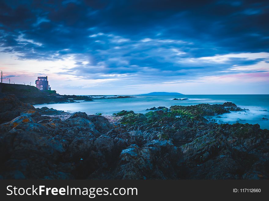 Lighthouse On Cliff Near Sea