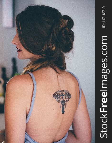 Woman With Black Elephant Tattoo in Back