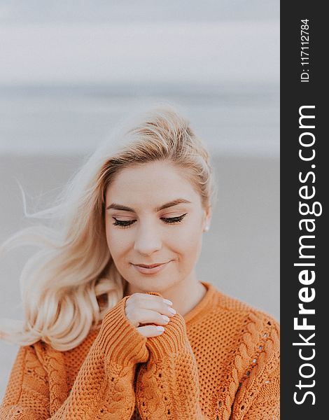 Blonde Haired Woman in Orange Knitted Long-sleeved Top