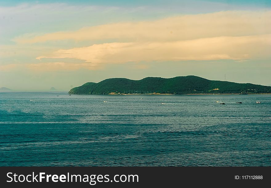 Body of Water With Background of Mountain during Golden Hour