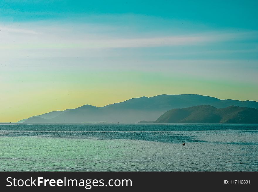 Body of Water Overlooking Islands Under Blue Daytime Sky