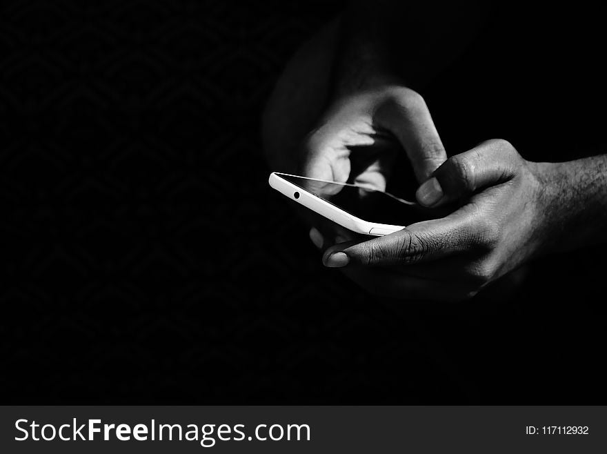 Grey Scale Photo of Person Holding Smartphone