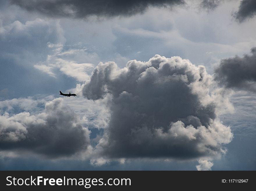 Airplane Flying Near Gray Clouds