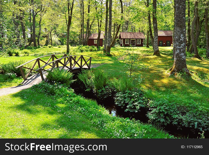 Brown Wooden House Near the Creek With a Bridge