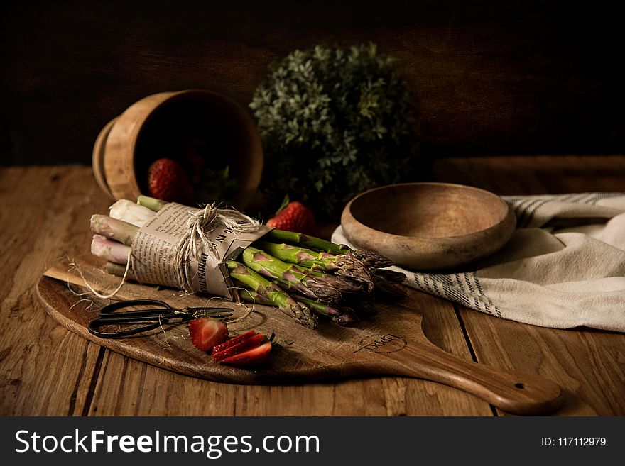 Asparagus on Wooden Board Beside Wooden Bowl