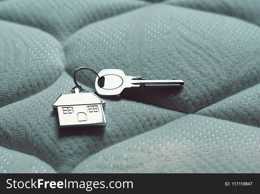 Home Key With House Keychain On Bed, Property Concept