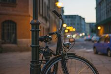 Bicycle In Retro Style Fastened To A Post In The Dark On A Street In A European City. Royalty Free Stock Photos