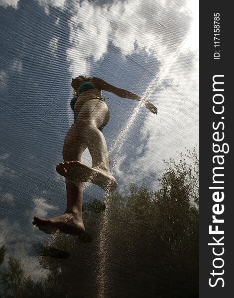 Girl jumping on elastic bed vertical