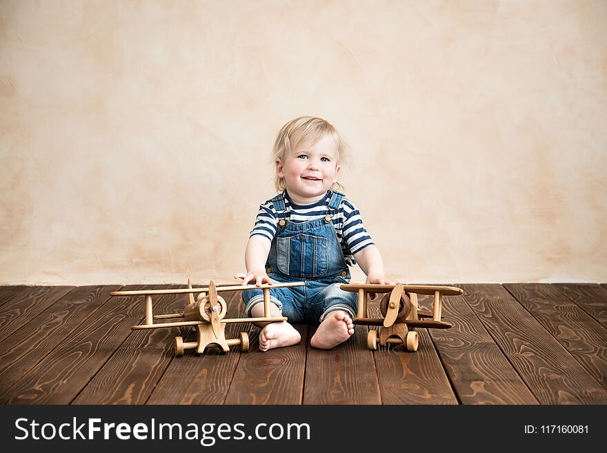 Happy child playing at home. Baby boy with toy airplane. Summer vacation and travel, dream and imagination concept. Happy child playing at home. Baby boy with toy airplane. Summer vacation and travel, dream and imagination concept