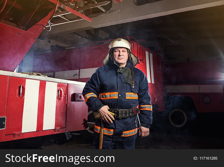 Fireman firefighter in action standing near a firetruck. Emergency safety. Protection, rescue from danger.