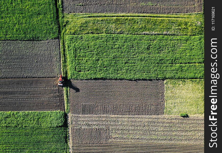 Aerial View Of Tractor Pulling Drill Sowing Seed In Field