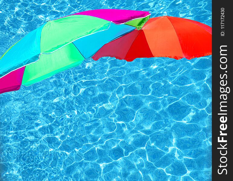 Bright color parasols over turquoise blue pool