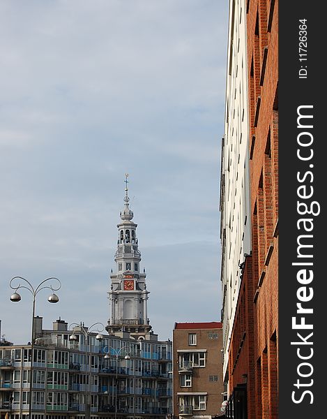 An old Amsterdam tower with a modern building on the right side. An old Amsterdam tower with a modern building on the right side