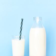 Milk In A Transparent Glass Bottle And In A Glass Glass Cup With A Tube Royalty Free Stock Images