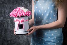 A Girl In A Blue Dress Is Holding A Bouquet Of Red And White, Pink And White Roses In A Hat Box. Dark Gray Background. Stock Image
