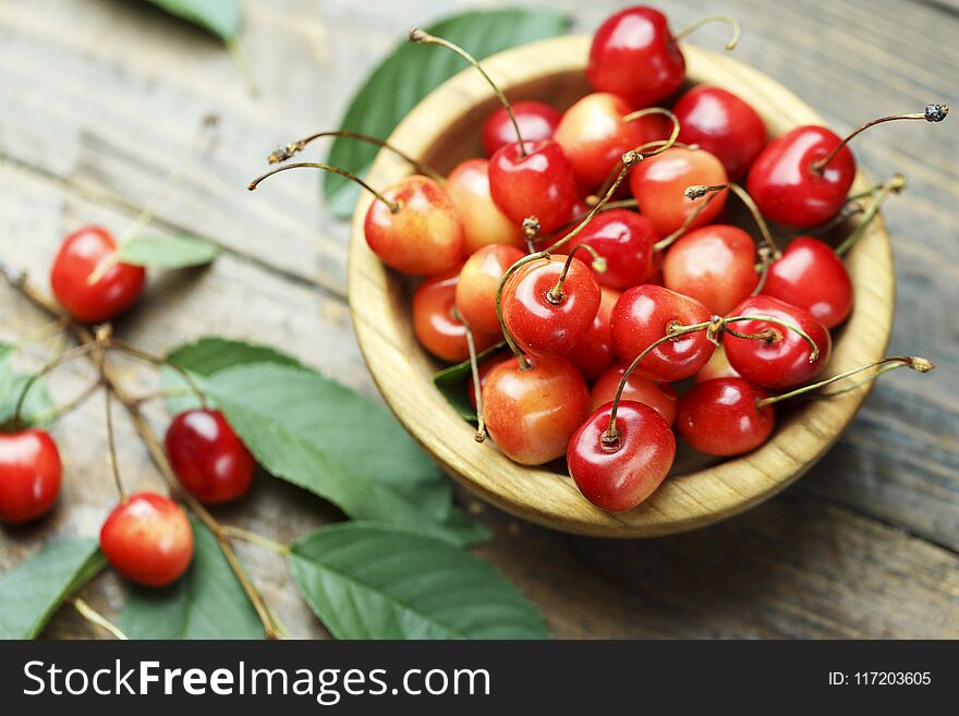 Sweet cherry on a wooden background. harvest of ripe berries in a plate. Sweet cherry on a wooden background. harvest of ripe berries in a plate