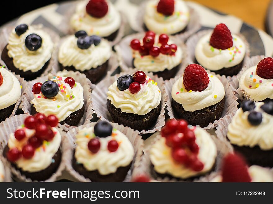 Different Dessert Tartlets With Cream And Fresh Blueberry And Raspberry.