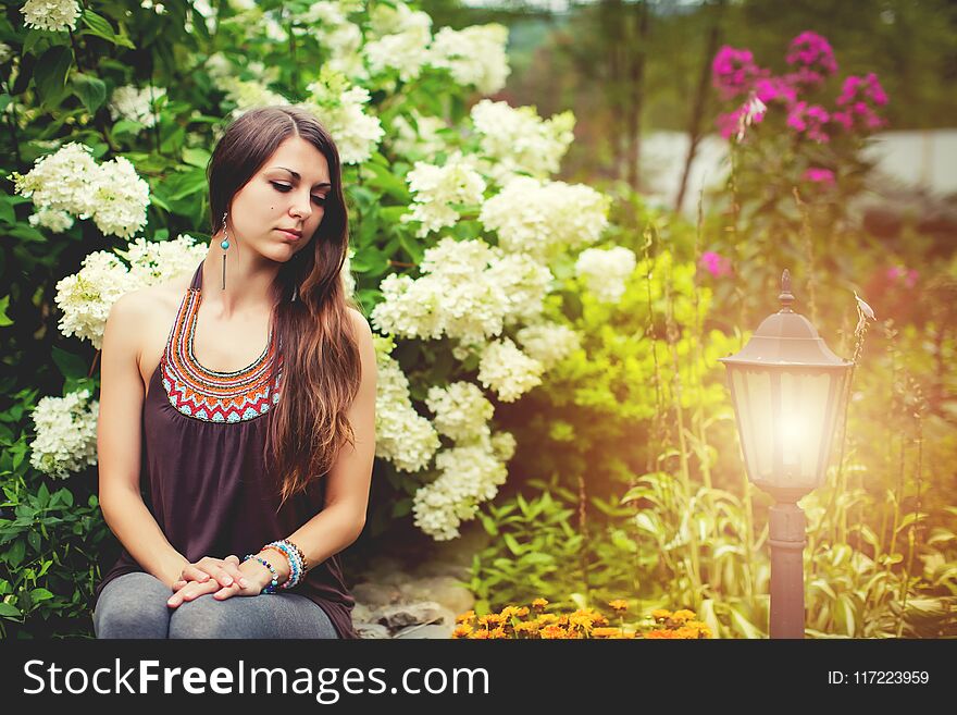 Close-up Outdoor Portrait Of Beautiful Pretty Woman In summer Garden near lighted torch. Close-up Outdoor Portrait Of Beautiful Pretty Woman In summer Garden near lighted torch