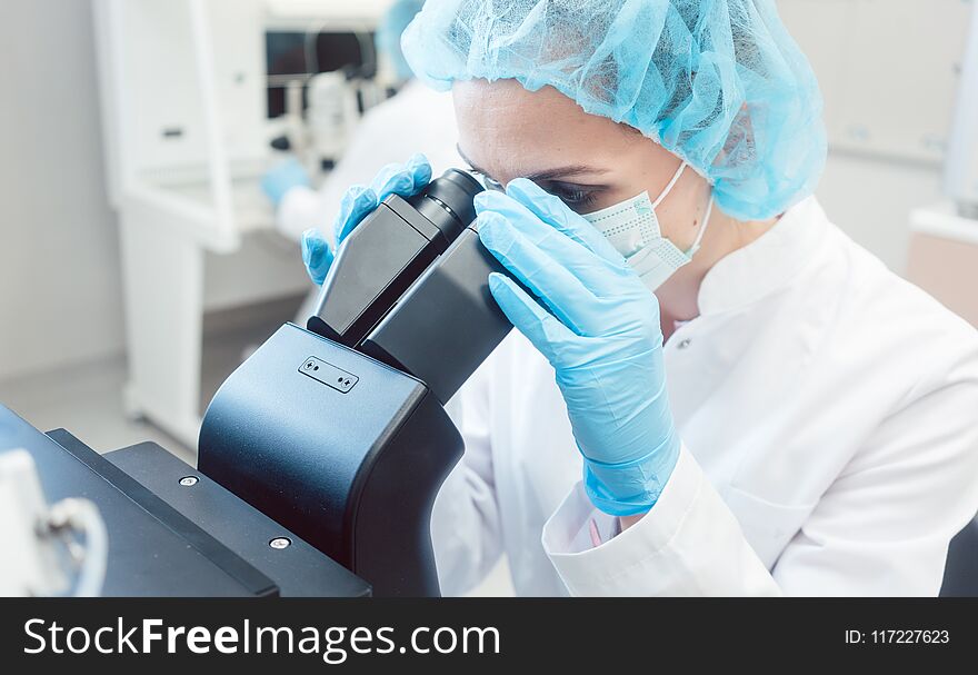 Woman Scientist Working On Microscope