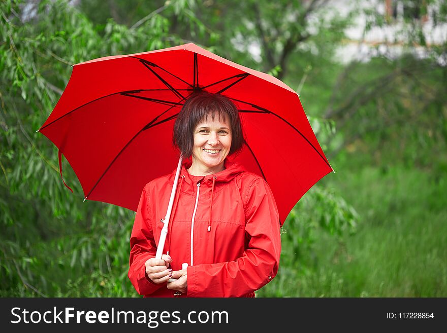 Woman in red portrait close-up on nature.