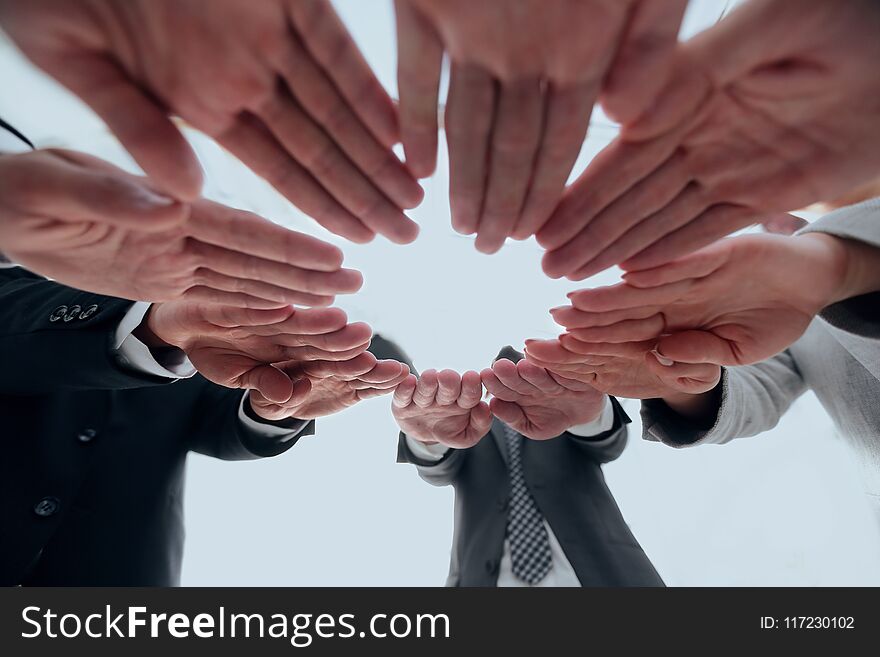 Concept of teamwork and unity. business team folding of the hands in a circle