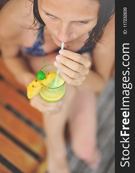 Young Girl At Swimming Pool Drinking Cocktail