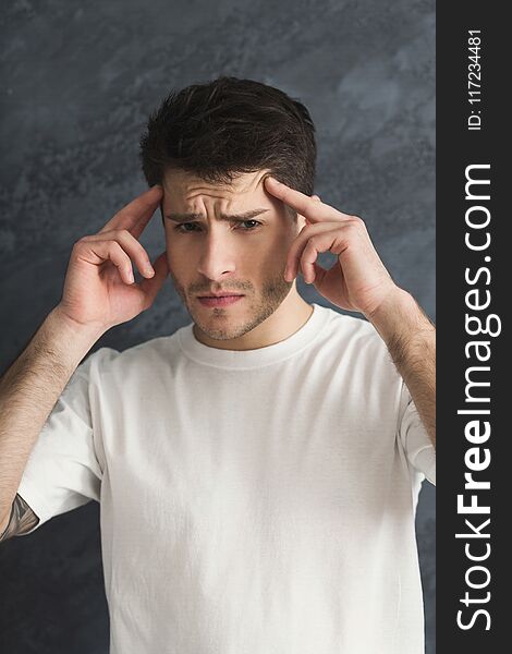 Young man wih headache cover head with hands. Exhausted depressed guy portrait, gray studio background. Young man wih headache cover head with hands. Exhausted depressed guy portrait, gray studio background