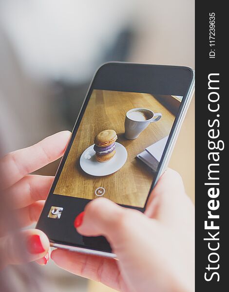 French colored macarons on the plate and a cup of coffee, soft focus background