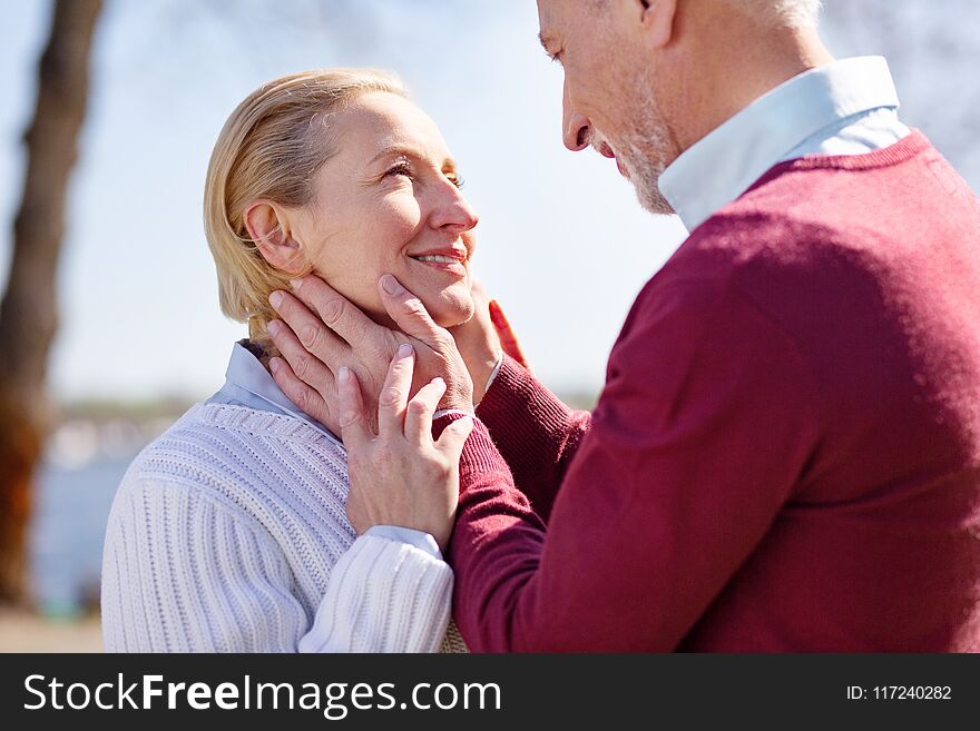 Romantic relationships. Happy nice men looking at his wifes face while being in love with her. Romantic relationships. Happy nice men looking at his wifes face while being in love with her