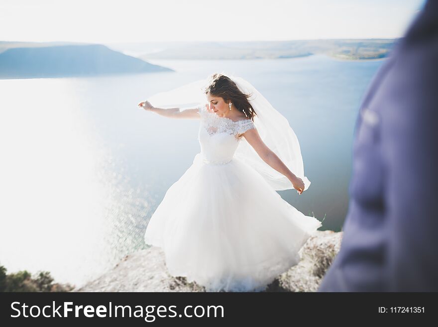 Elegant stylish happy wedding couple, bride, gorgeous groom on the background of sea and sky.