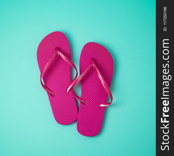 Minimal summer concept. Pink flip flops over blue background. View from above