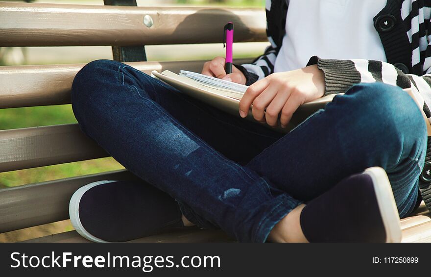 Outdoor park education. leisure time. Young cute teen sitting bench reading book.