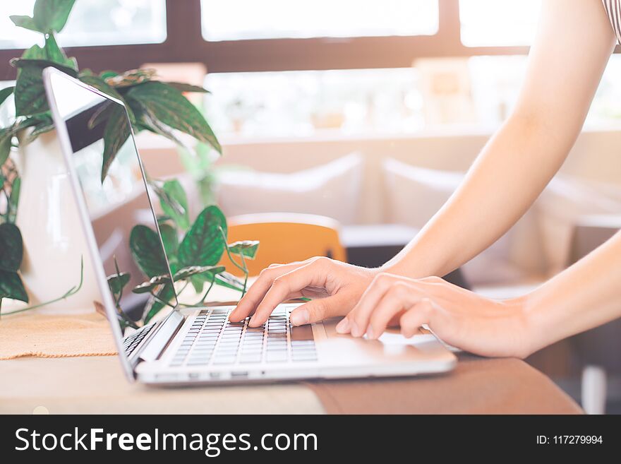 Woman hand works on a laptop computer in the office.