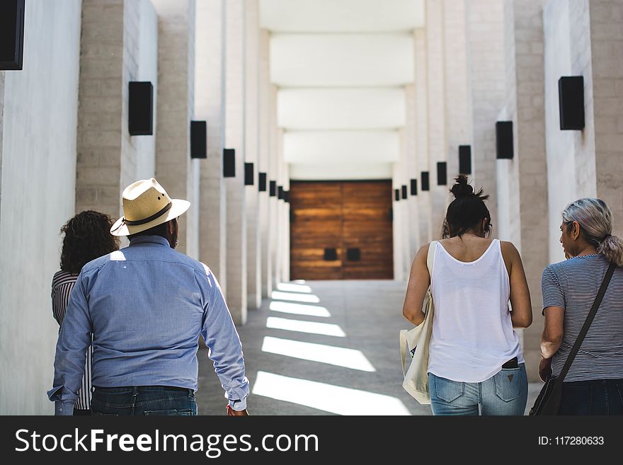 Man In Gray Long-sleeved Shirt Near White Wall