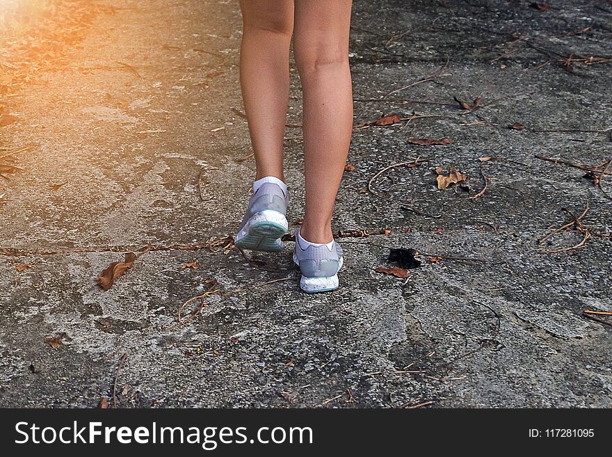 Young Woman Jogging Close-up on the road