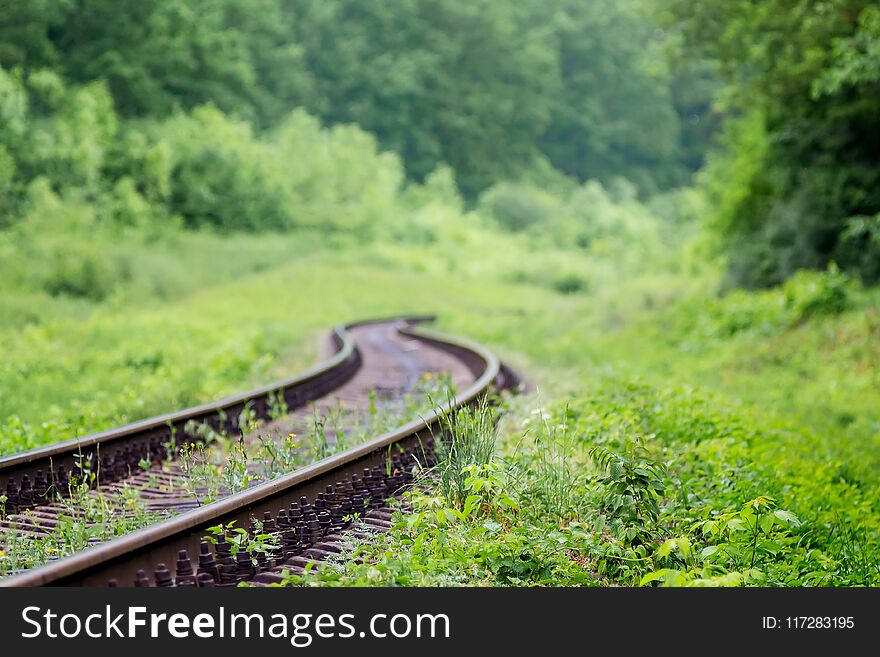 Railway track going to zigzag among picturesque nature. Travel and freight transportation