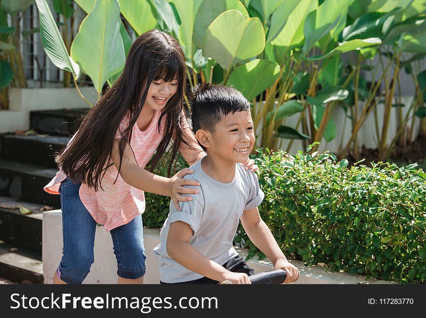 Kid Having Fun With Sister Riding A Bike