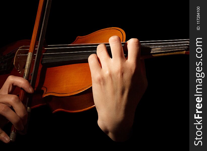Violin and bow in hands of musician, isolated on black