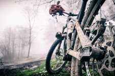 Mountain Bike And Helmet In Autumn Woods, Dirty Bicycle Royalty Free Stock Image