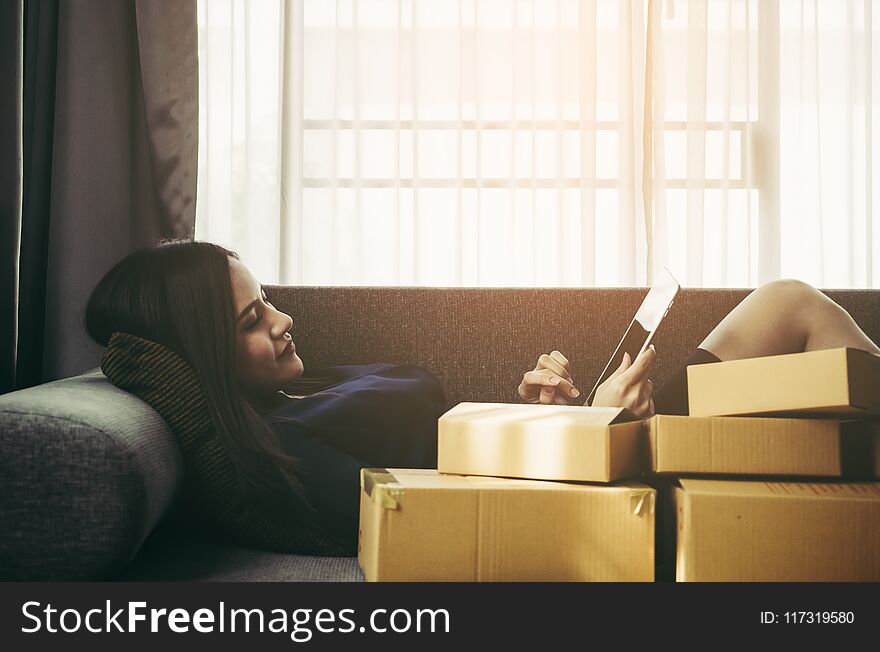 Asian woman shopaholic on tablet full of boxes