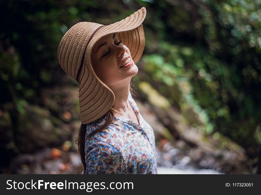 Portrait of young attractive female smiling in a jungle forest, summer vacation. Young woman enjoying fresh air in the